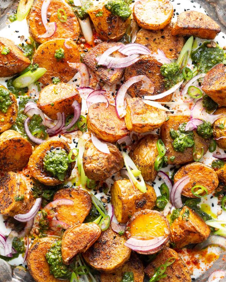 Roasted baby potatoes with yoghurt, coriander pesto, red onion, spring onion and spices