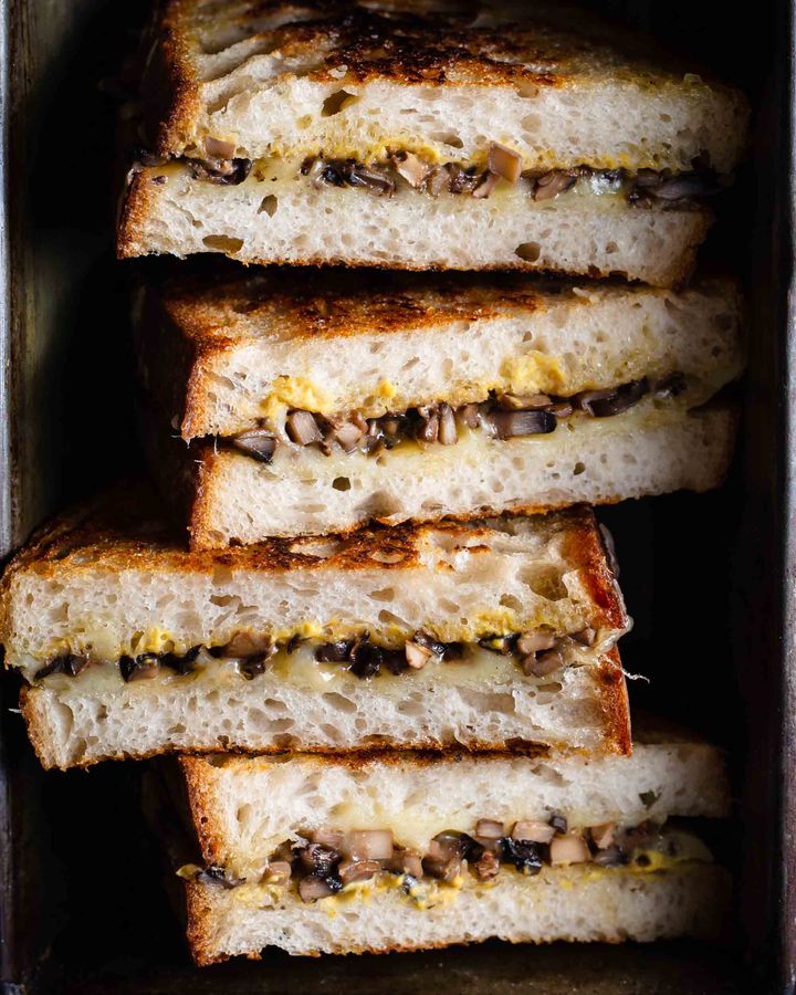 Close up of mushroom and cheese toasties on a dark background