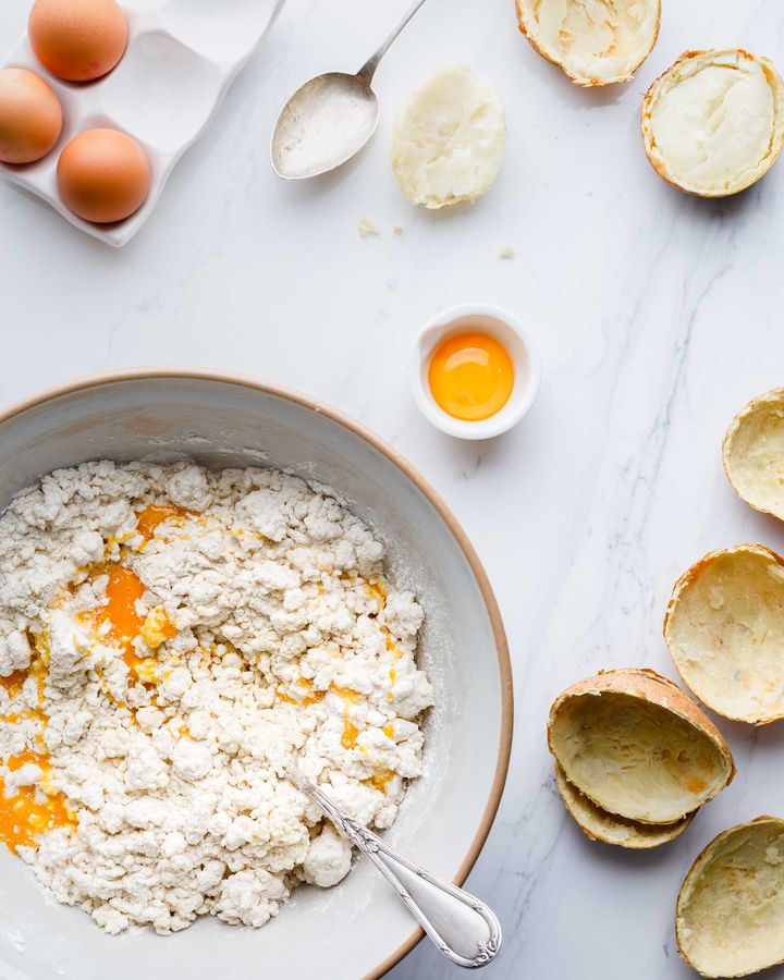 Gnocchi making in progress with baked potato skins and egg yolk