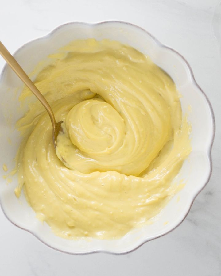Bowl of yellow aioli garlic mayonnaise with a spoon